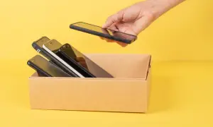 Chcesz wiedzieć, jak sprawdzić model telefonu? W pudełku leżą telefony, a ręka wyciąga kolejny.