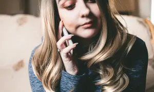 Kobieta rozmawia przez telefon, szukając informacji, jak włączyć roaming T-Mobile kodem.