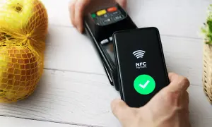 Płatność zbliżeniowa telefonem. Ekran pokazuje "NFC Payment" i zielony znaczek. Dowiedz się, jak włączyć NFC w telefonie, by płacić wygodnie.