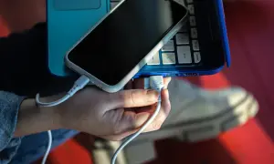 Ręka podłącza telefon do laptopa przez USB. Prosty sposób, jak połączyć telefon z komputerem przez USB, by przesyłać dane lub ładować urządzenie.