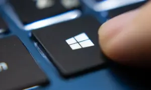 Palec naciska klawisz Windows, rozpoczynając aktualizację sterowników Windows 10.