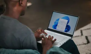 Mężczyzna pisze na laptopie z systemem Windows 11. Chcesz wiedzieć, jak zmienić nazwę użytkownika Windows 11?