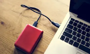 Czerwony dysk zewnętrzny podłączony do laptopa. Komputer nie widzi dysku zewnętrznego, co może być frustrujące.