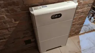Biały magazyn energii 10kW, stojący przy ceglanej ścianie, zapewnia niezależność energetyczną.