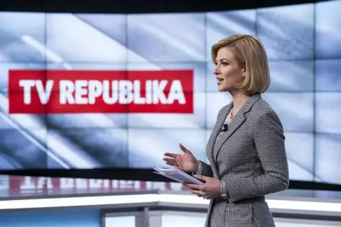 Prezenterka w studio TV Republika z dokumentami w ręku.
