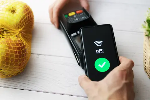 Płatność zbliżeniowa telefonem. Ekran pokazuje "NFC Payment" i zielony znaczek. Dowiedz się, jak włączyć NFC w telefonie, by płacić wygodnie.