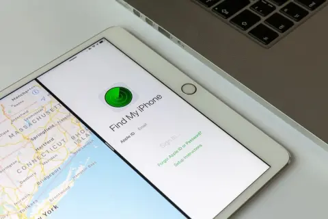 Tablet z mapą i aplikacją "Find My iPhone" do lokalizacji telefonu. Obok klawiatura laptopa.