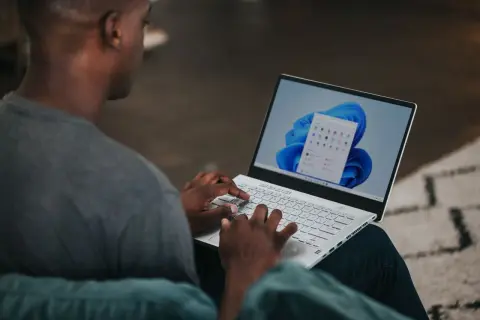 Mężczyzna pisze na laptopie z systemem Windows 11. Chcesz wiedzieć, jak zmienić nazwę użytkownika Windows 11?