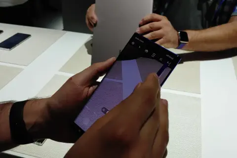 Ręka trzyma smartfon z włączoną funkcją AR Emoji. Widać ikonę "AR Emoji" na ekranie.