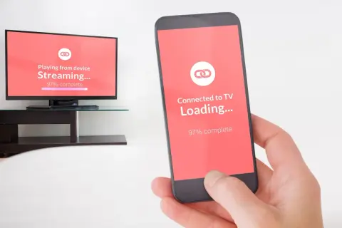 Smartfon i telewizor pokazują proces ładowania, niemal gotowe do mirroring.