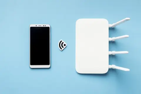 Biały smartfon i router Wi-Fi obok symbolu połączenia. Dowiedz się, jak udostępnić internet z telefonu na telefon.