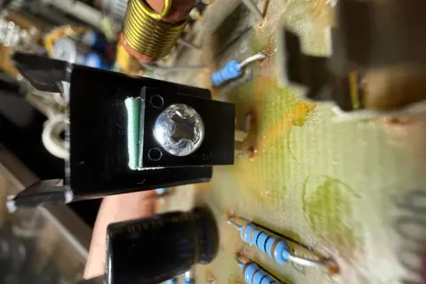 Element bd139 zamontowany na radiatorze, przykręcony do płytki drukowanej. Widać rezystory i kondensator.