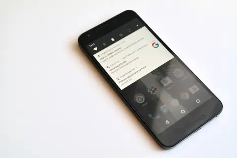 Czarny smartfon z powiadomieniem o pobraniu aktualizacji systemu Android 7.0 Nougat.