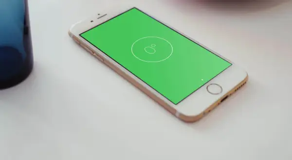 Złoty telefon z zielonym ekranem, na którym widać ikonę poziomicy.