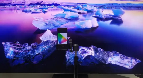Telefon z kolorowym wzornikiem na tle lodowca. Idealny do kalibracji telewizora, by kolory były żywe jak na tym mroźnym krajobrazie.