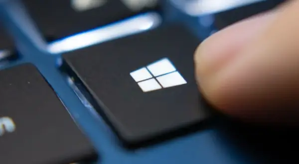 Palec naciska klawisz Windows, rozpoczynając aktualizację sterowników Windows 10.