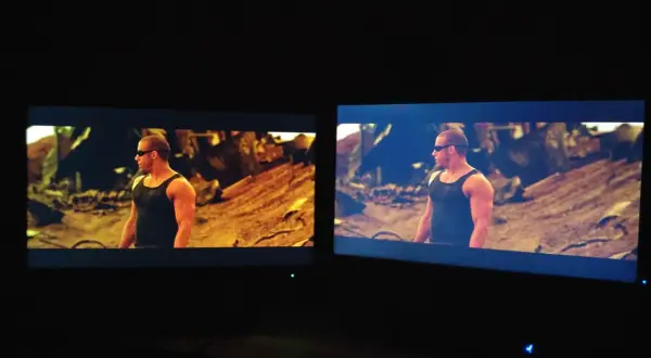 Dwa monitory pokazują tę samą scenę z filmu. Na lewym monitorze, z technologią matryca VA, kolory są cieplejsze, a na prawym chłodniejsze.