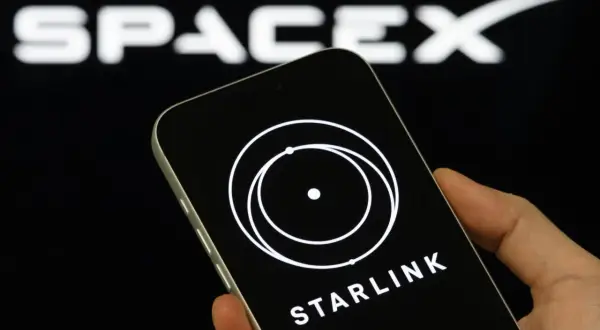 Telefon z logo Starlink i napisem "STARLINK" na tle logo SpaceX. Wiele osób szuka starlink opinie przed zakupem.