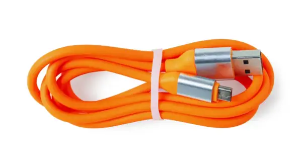 Pomarańczowy kabel USB z wtyczkami USB-A i micro USB. Czy silikon przewodzi prąd? Ten kabel pokazuje, że jego izolacja nie przewodzi.
