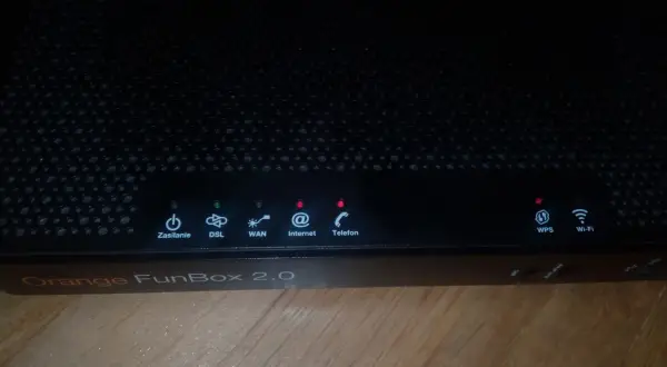 Czarny router Orange FunBox 2.0 z migającymi diodami sygnalizującymi stan połączenia.