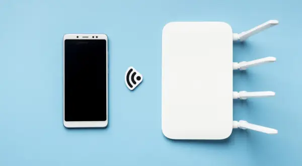 Biały smartfon i router Wi-Fi obok symbolu połączenia. Dowiedz się, jak udostępnić internet z telefonu na telefon.