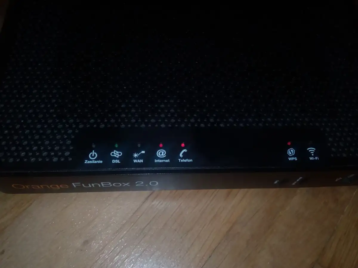 Czarny router Orange FunBox 2.0 z migającymi diodami sygnalizującymi stan połączenia.