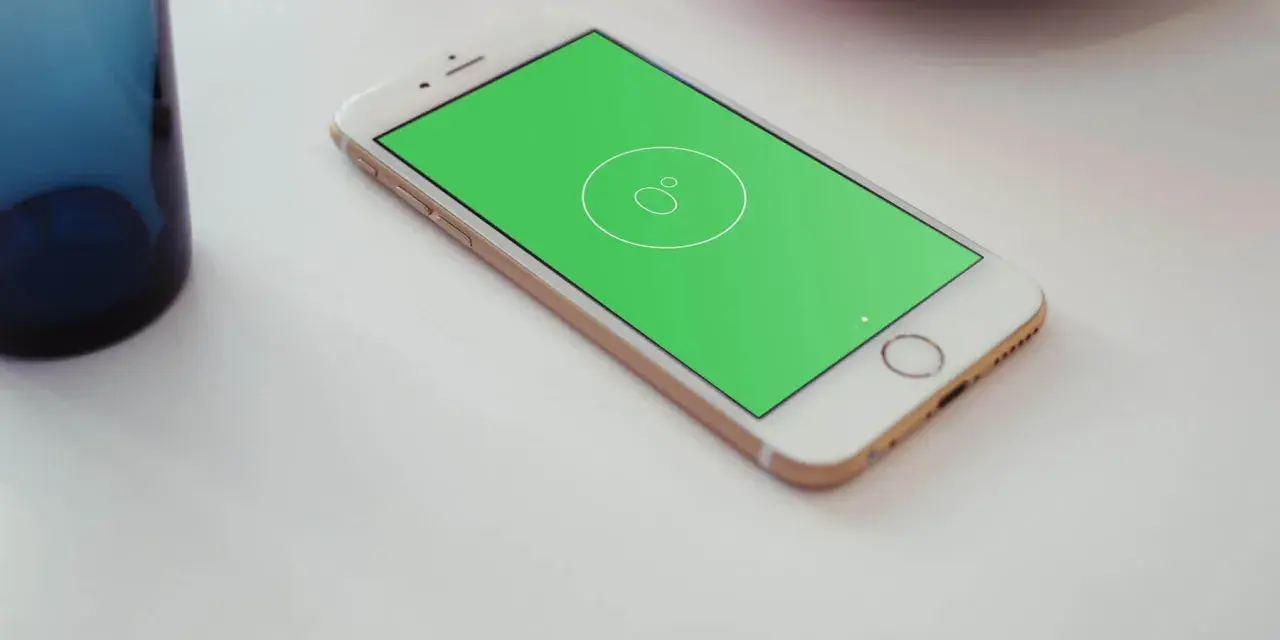 Złoty telefon z zielonym ekranem, na którym widać ikonę poziomicy.