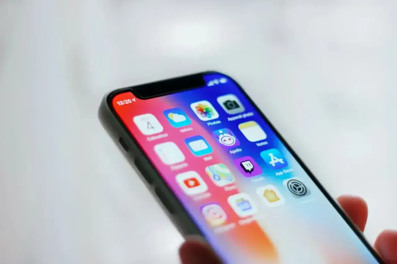 Ekran iPhone'a z ikonami aplikacji. Ustawienia kontroli rodzicielskiej iPhone pomagają zarządzać dostępem do treści.