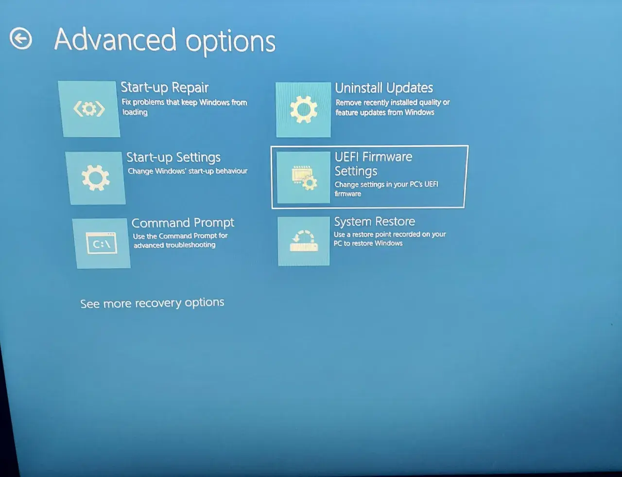 Ekran zaawansowanych opcji odzyskiwania systemu Windows. Widoczne opcje to: Naprawa systemu, Odinstaluj aktualizacje, Ustawienia uruchamiania, Ustawienia oprogramowania układowego UEFI (BIOS), Wiersz polecenia i Przywracanie systemu.