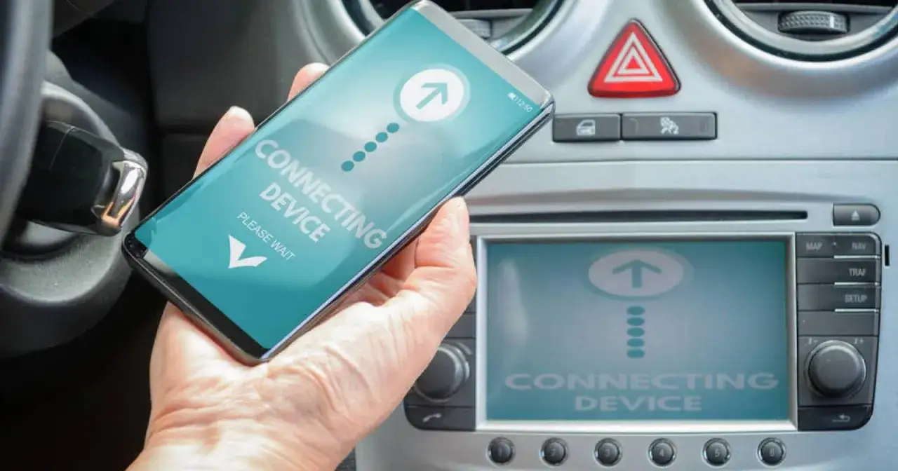 Dłoń trzyma smartfon z napisem 