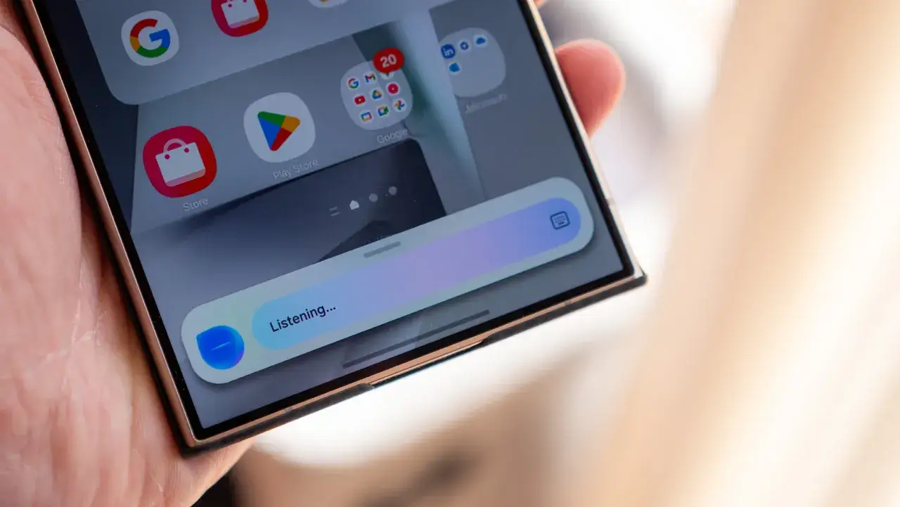 Dłoń trzyma smartfon, na ekranie którego widać pasek wyszukiwania z napisem 