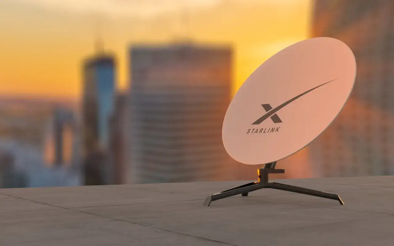 Antena Starlink na tle zachodzącego słońca nad miastem. Czy warto zainwestować? Sprawdź starlink opinie.