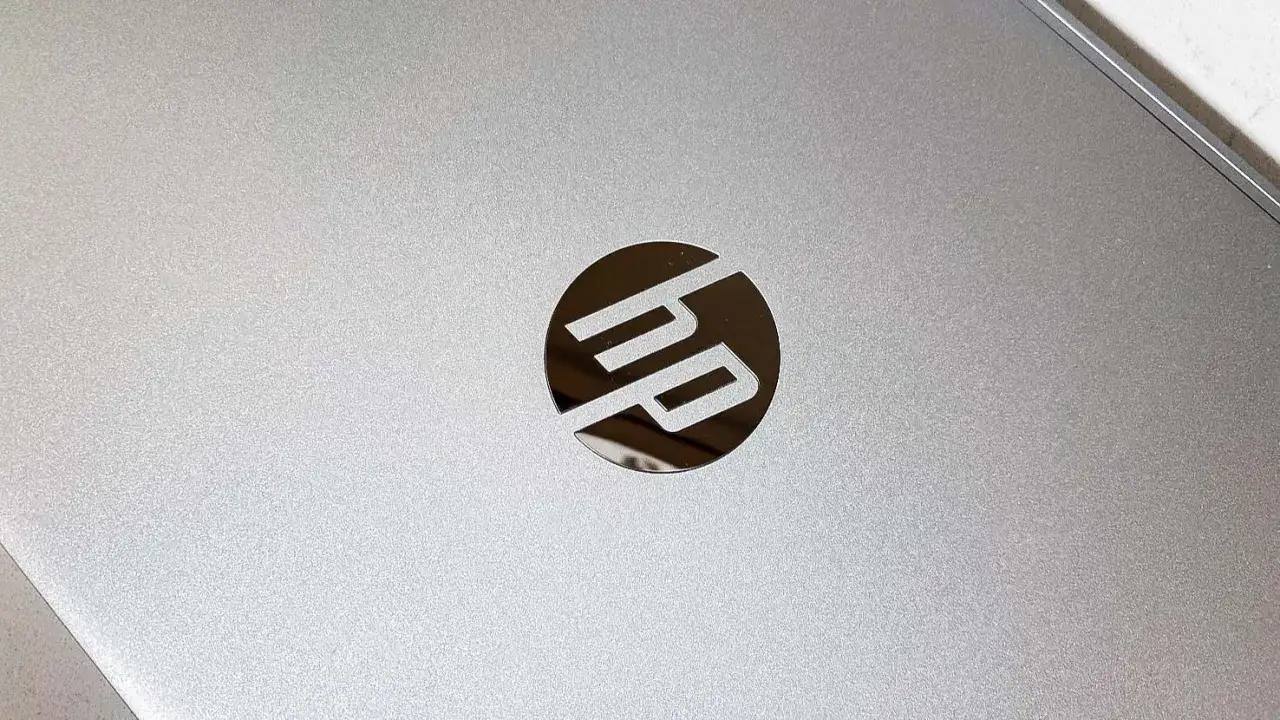 Srebrna obudowa laptopa HP z błyszczącym logo. Po uruchomieniu komputera, ekran BIOS HP pojawia się jako pierwszy.