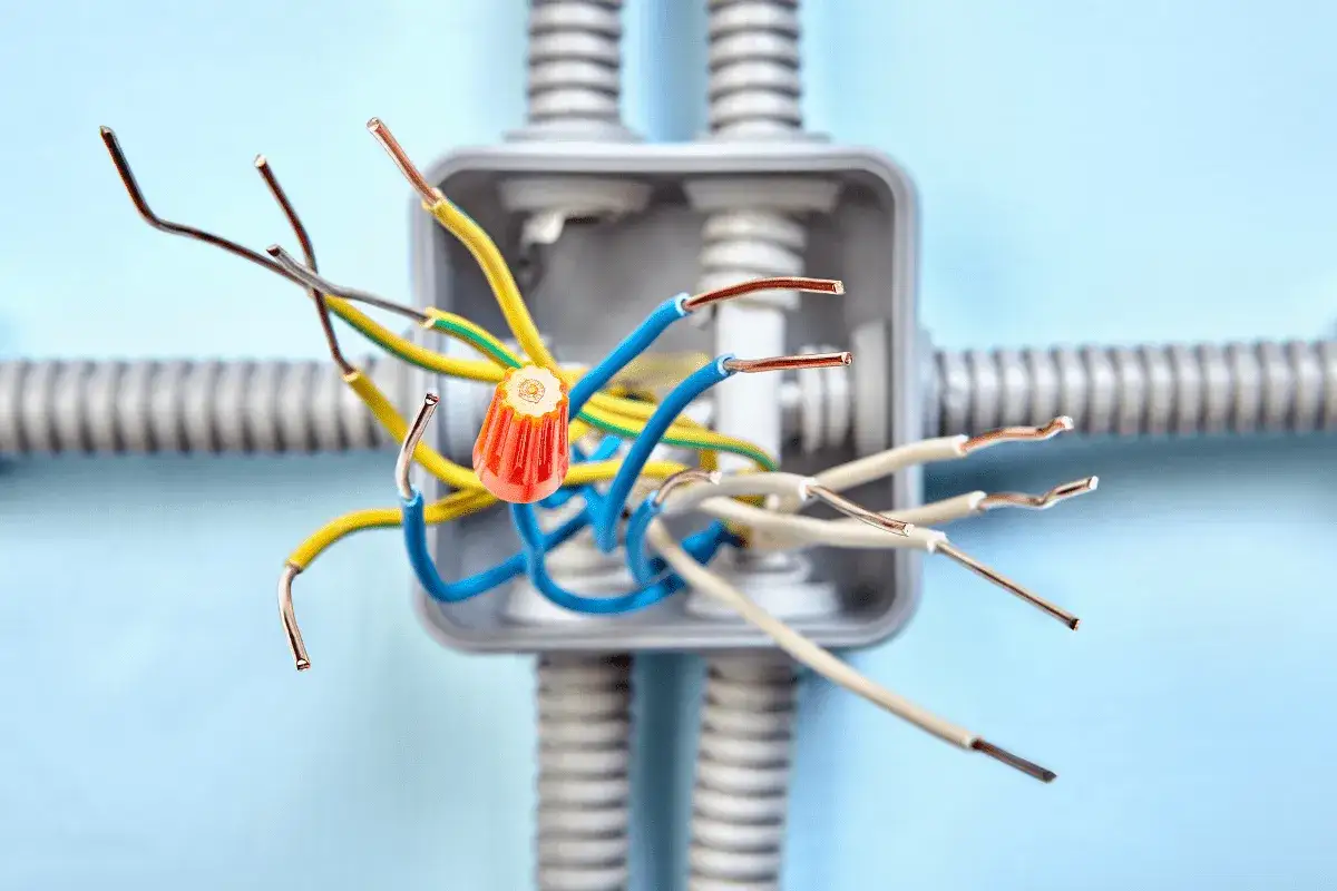 Instalacja elektryczna bezpuszkowa z kolorowymi przewodami i pomarańczowym złączem.