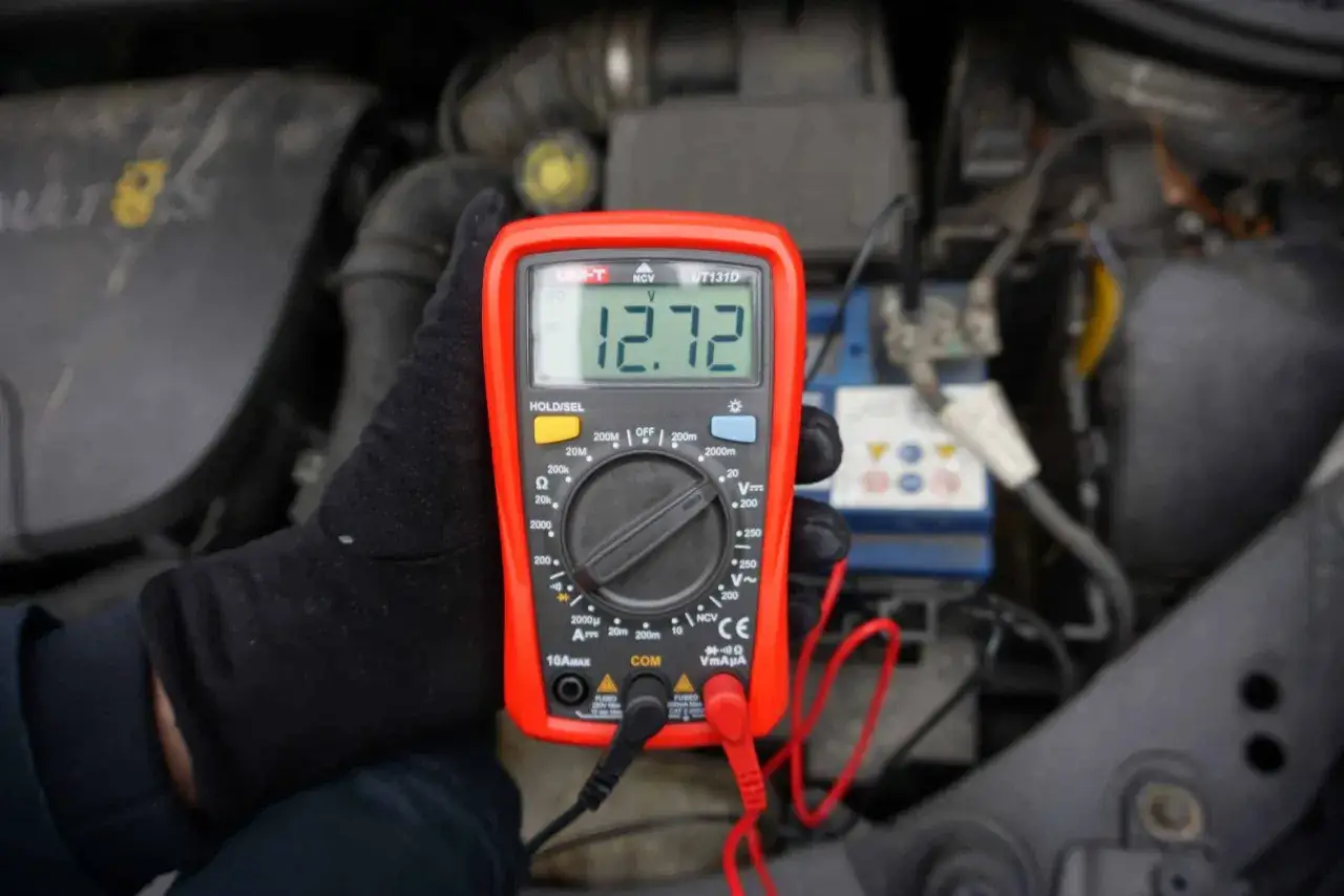 Sprawdzanie akumulatora miernikiem. Wynik 12.72V pokazuje, że jest naładowany.