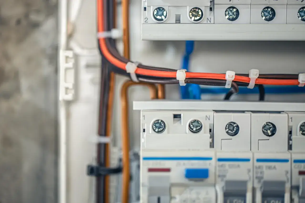 Nowoczesna instalacja elektryczna bezpuszkowa z uporządkowanymi przewodami i wyłącznikami.