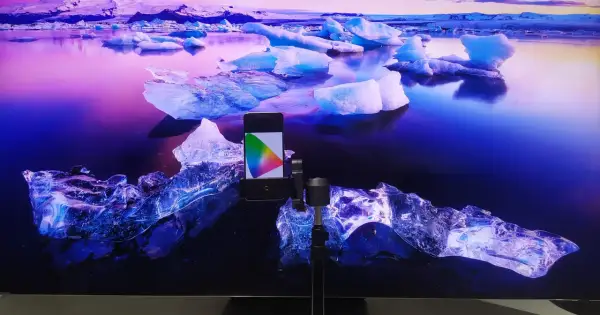 Telefon z kolorowym wzornikiem na tle lodowca. Idealny do kalibracji telewizora, by kolory były żywe jak na tym mroźnym krajobrazie.