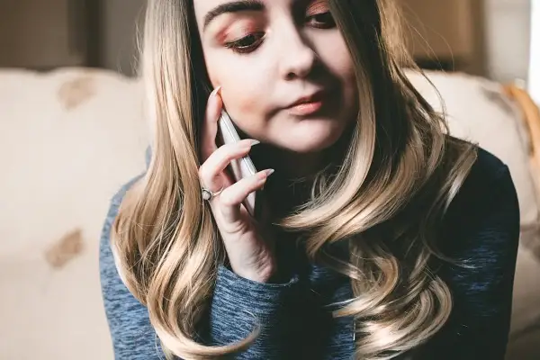 Kobieta rozmawia przez telefon, szukając informacji, jak włączyć roaming T-Mobile kodem.