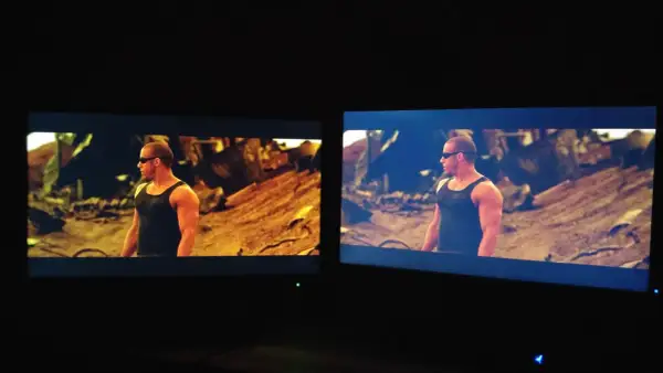 Dwa monitory pokazują tę samą scenę z filmu. Na lewym monitorze, z technologią matryca VA, kolory są cieplejsze, a na prawym chłodniejsze.
