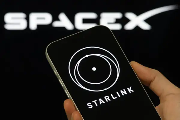 Telefon z logo Starlink i napisem "STARLINK" na tle logo SpaceX. Wiele osób szuka starlink opinie przed zakupem.