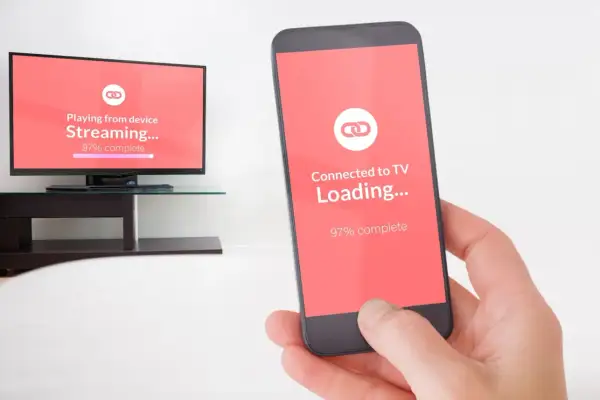 Smartfon i telewizor pokazują proces ładowania, niemal gotowe do mirroring.