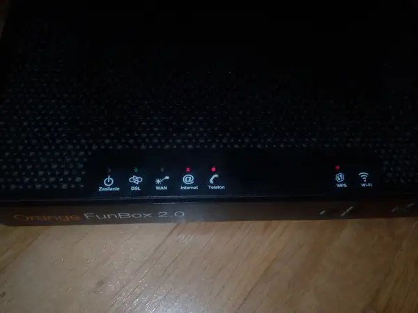 Czarny router Orange FunBox 2.0 z migającymi diodami sygnalizującymi stan połączenia.